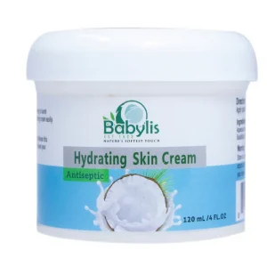 A white plastic tub of Babylis Hydrating Skin Cream with a smooth white lid. The front label features the Babylis logo, which states "EST 1983" and "NATURE'S SOFTEST TOUCH." The words "Hydrating Skin Cream" are printed inside a grey rectangular banner, with a green badge below it that reads "Antiseptic." The bottom portion of the label has a light blue background featuring an illustration of a coconut half splashing into milk or cream, alongside the volume marking "120 mL / 4 FL.OZ