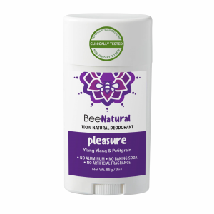 A deodorant stick from the brand "BeeNatural." The deodorant is called "pleasure" and is labeled as "100% NATURAL DEODORANT." The product features a purple label with text listing the scents "Ylang-Ylang & Petitgrain" and states "NO ALUMINUM • NO BAKING SODA • NO ARTIFICIAL FRAGRANCE." The label also says "Non-Irritant To Skin," "Clinically Tested," and "Certified By SGS IDEAS Clinic." The weight is listed as "Net Wt. 85g / 3oz." The packaging is a white twist-up style stick with a white cap.