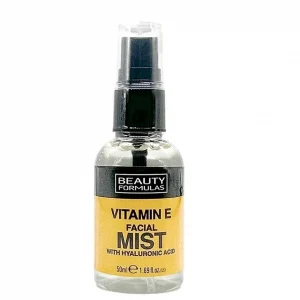 A clear plastic spray bottle of Beauty Formulas Vitamin E Facial Mist, set against a plain white background. The bottle features a black spray pump with a clear protective cap. The front label has a black top bar showcasing the white "BEAUTY FORMULAS" logo, with the main body of the label colored a bright golden yellow. The text on the yellow section reads "VITAMIN E FACIAL MIST WITH HYALURONIC ACID" in bold black lettering, with the volume "50ml e 1.69 fl.oz.(US)" printed at the bottom.
